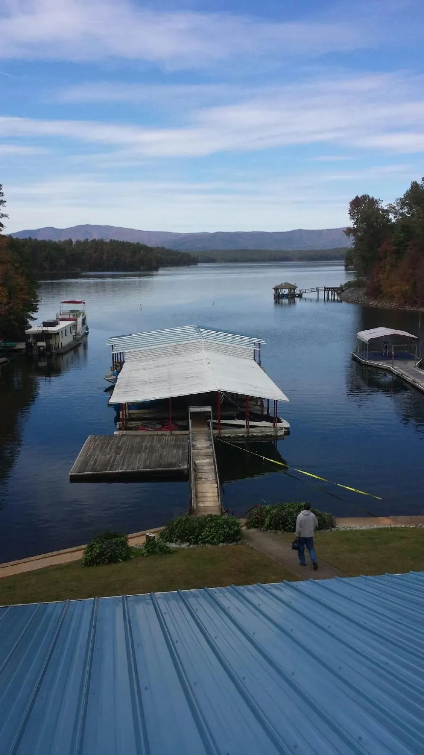 View across a lake from a newly installed blue metal roof in Winlock